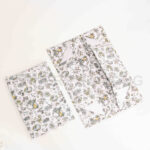 Separate flat-packed components (lid and base) of a custom floral print foldable rigid box.